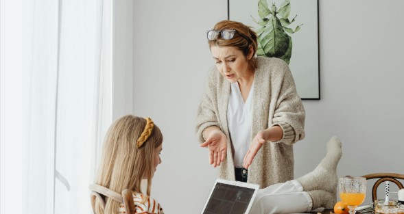 Dochter met tablet en vermanende moeder.